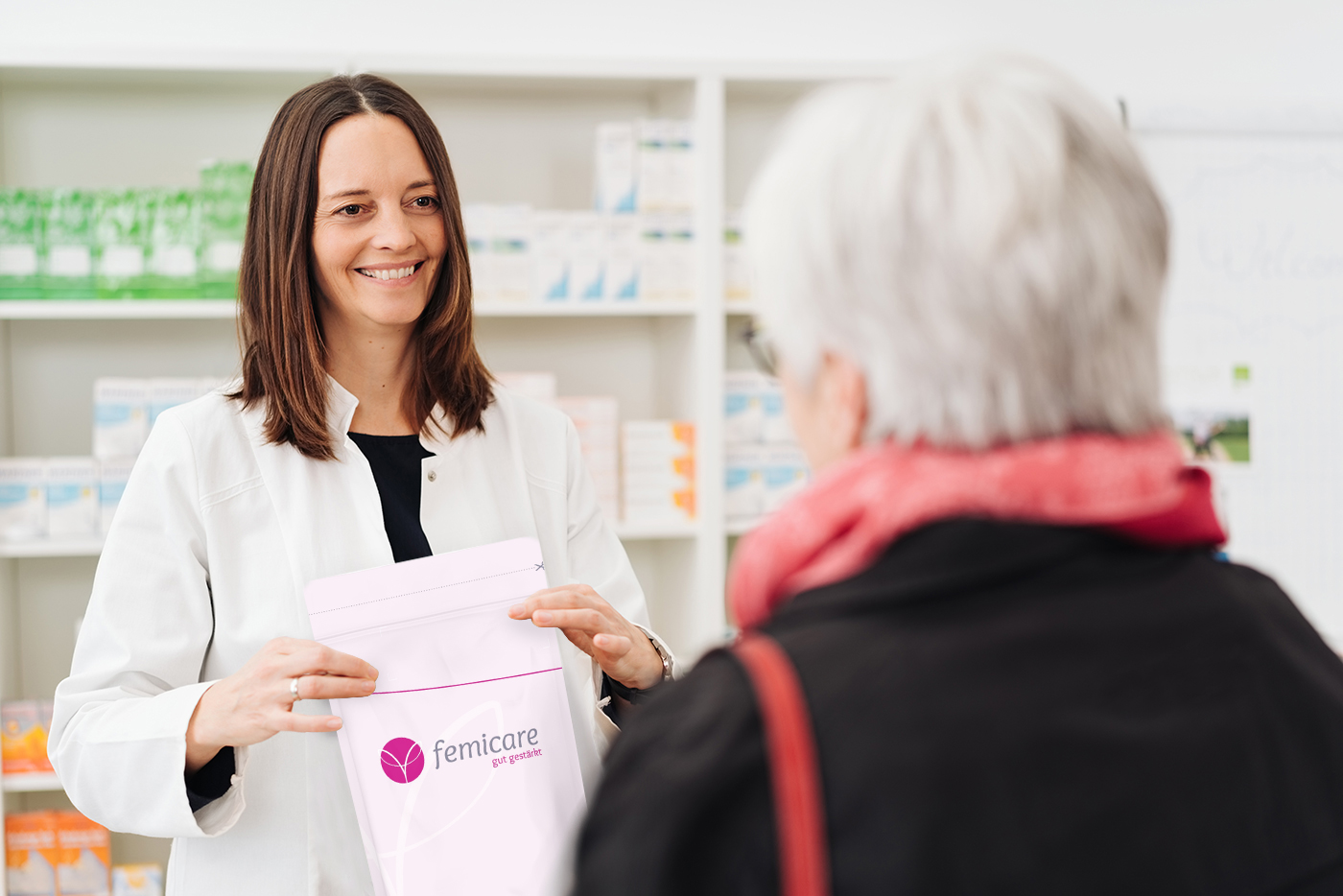 Eine Frau übergibt einer Patientin ihr femicare Pessar, das sie über ein Rezept erhalten hat.
