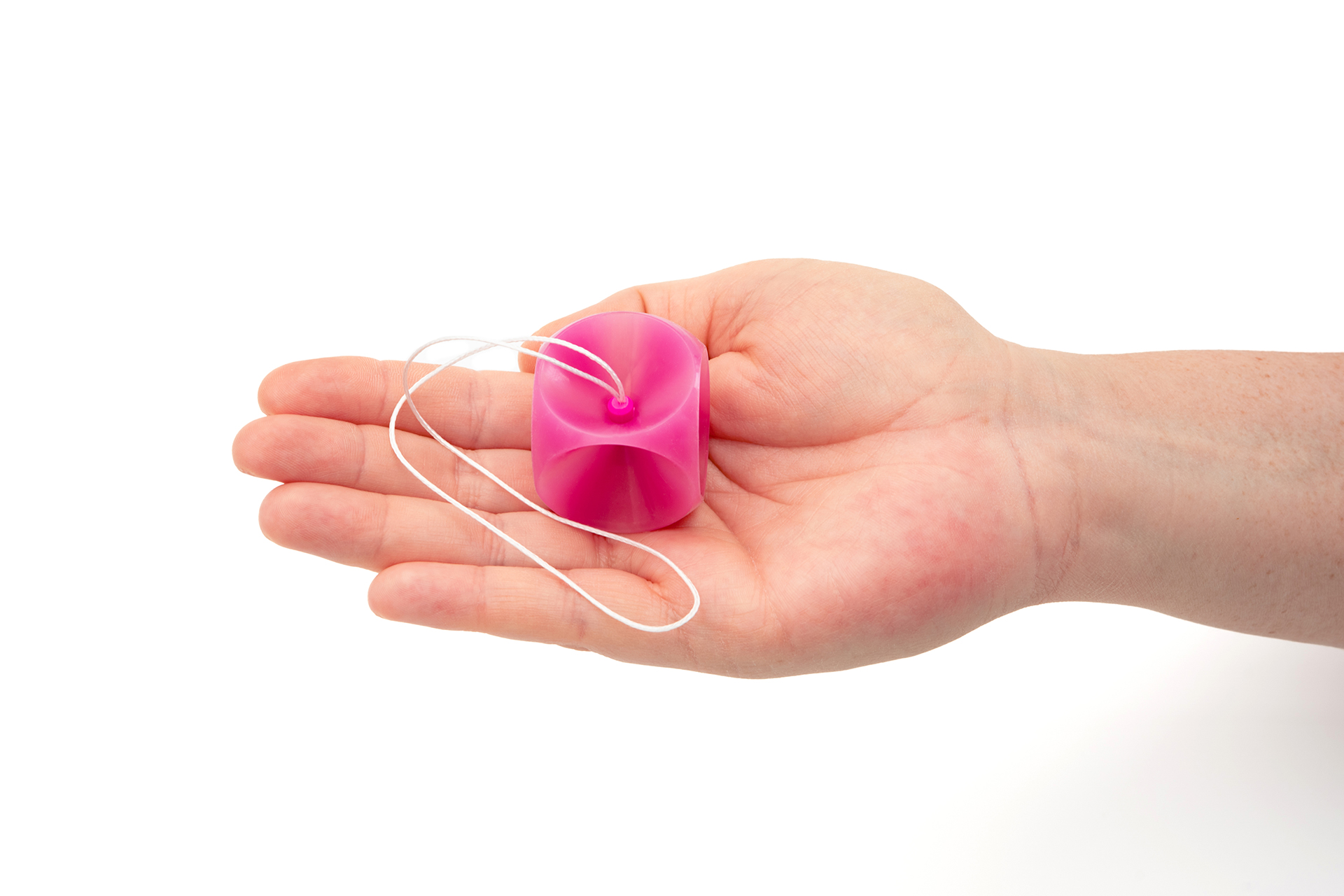 Ein pinkes femicare Würfel-Pessar der Größe 41 liegt in einer ausgestreckten Hand.